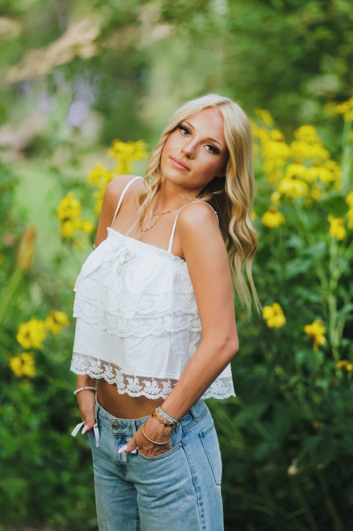 blonde teen stands in front of sunflowers during Boulder Senior Portrait Session